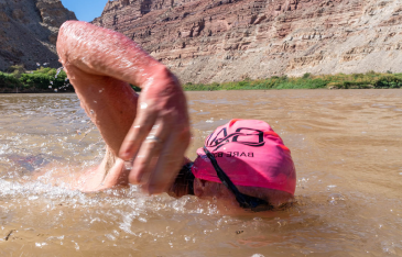 Person swimming in river in canyon